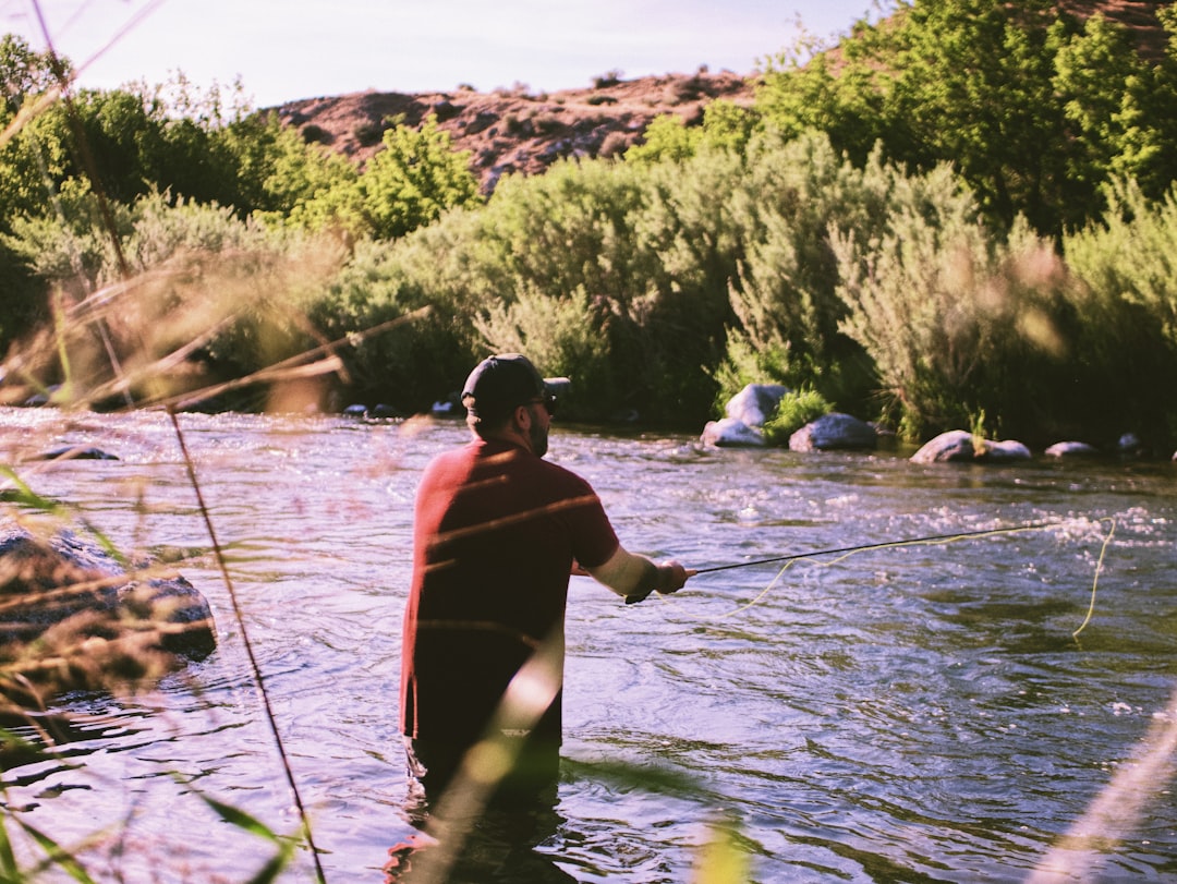 Person fishing on calm water during daytime
